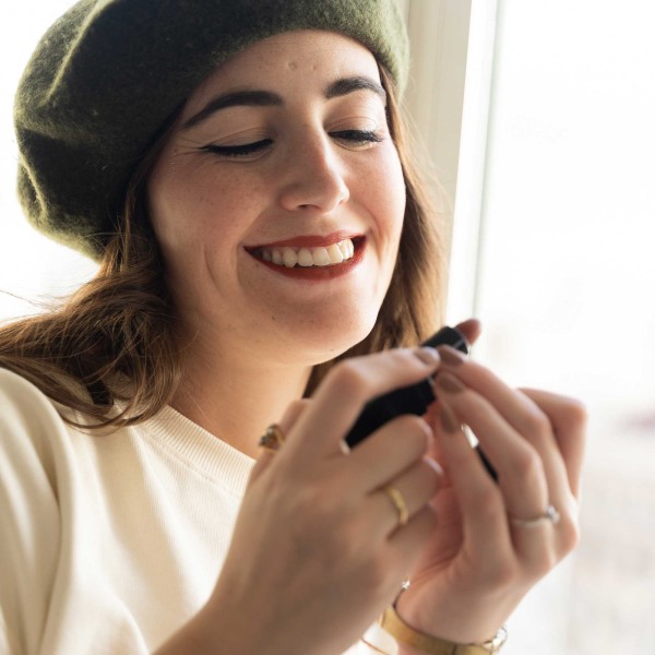 Mujer sonriente mostrando pintalabios color black baccara