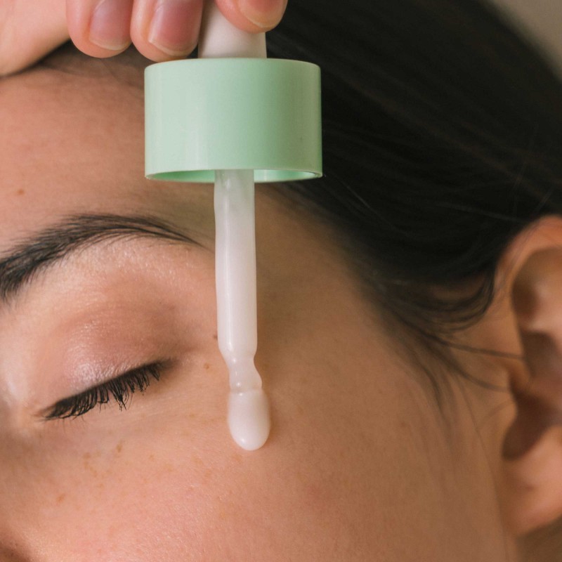 Drop of moisturizing serum running down on delicate woman cheek