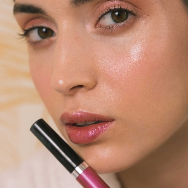 Woman lips close-up wearing lip gloss intense rose color