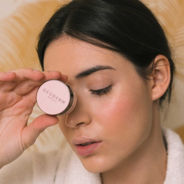 Rostro de mujer mostrando colorete en polvo color rosa intenso