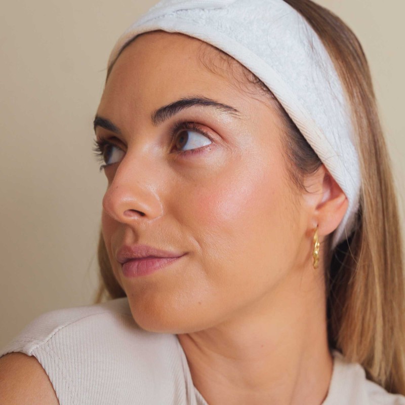 mujer con maquillaje natural, sombras veganas en tonos tierra, colorete rosado e iluminador dorado