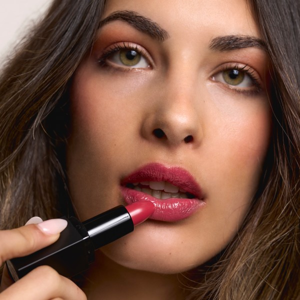 chica pintándose los labios con el tono strawberry